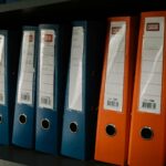 Organized shelf of colorful office binders representing shell and shelf companies, legal documents, and compliance in German business law